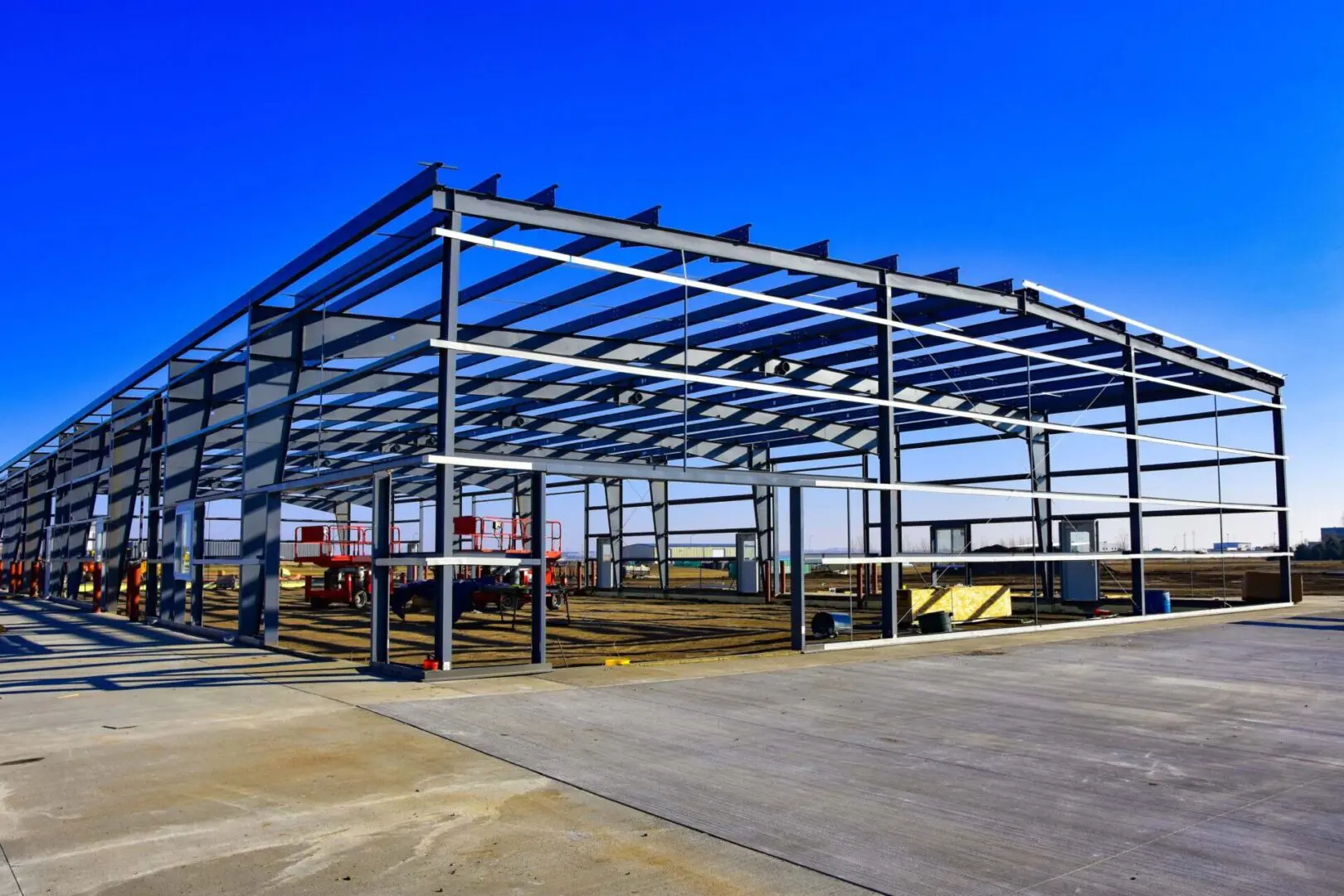 Steel frame structure under clear blue sky.