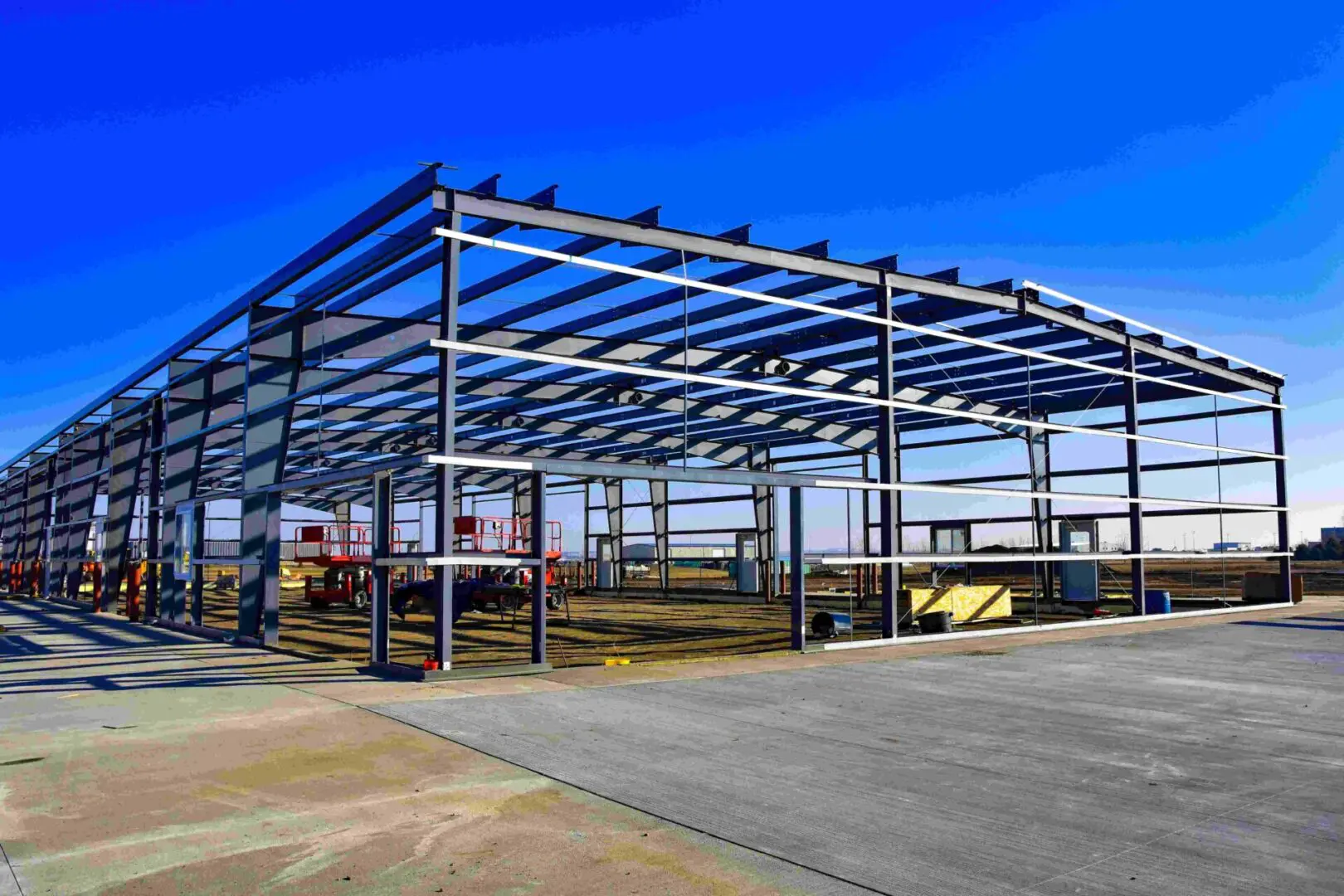 Steel structure under construction against blue sky.
