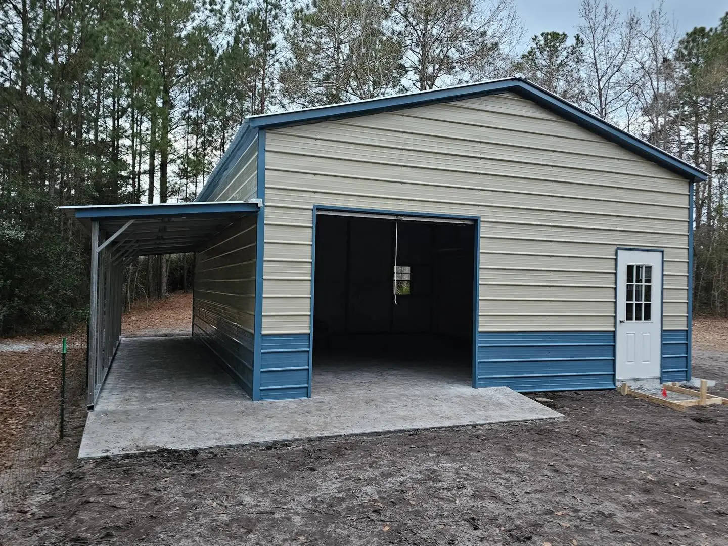 Cream garage with blue trim and an adjoining lean-to