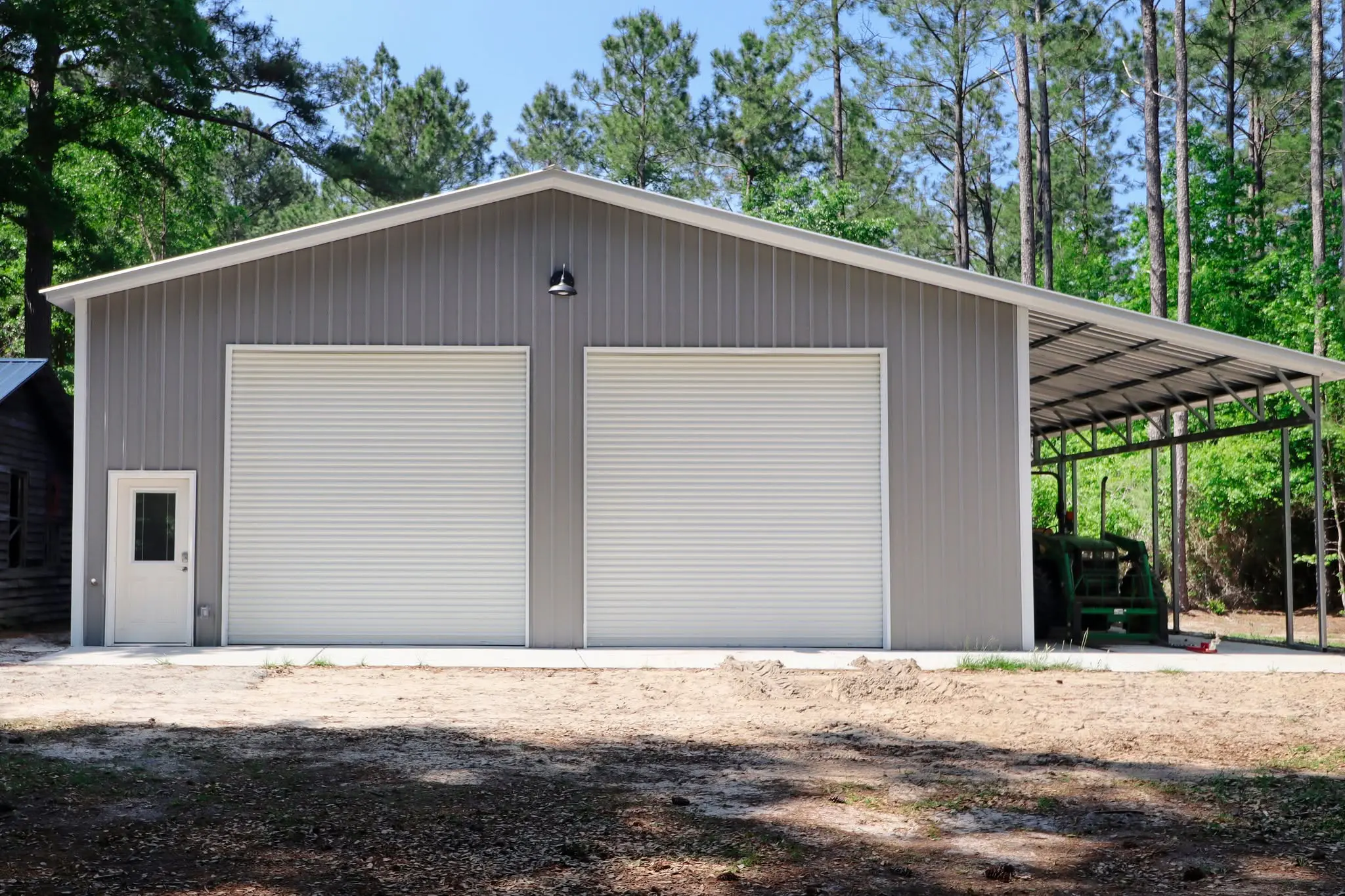 Front view of a gray garage with a covered tractor bay