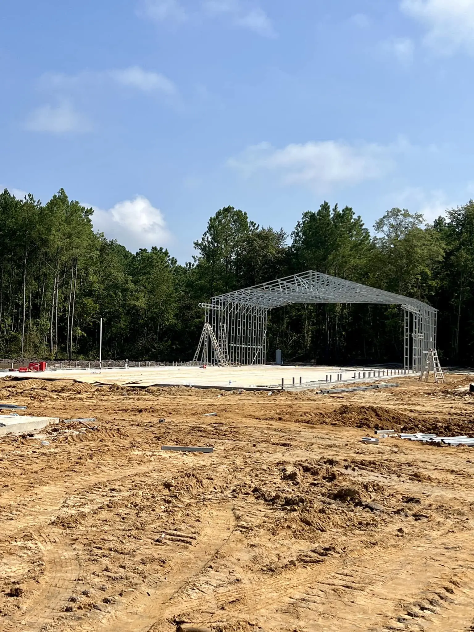 Steel building frame being erected on a large concrete slab