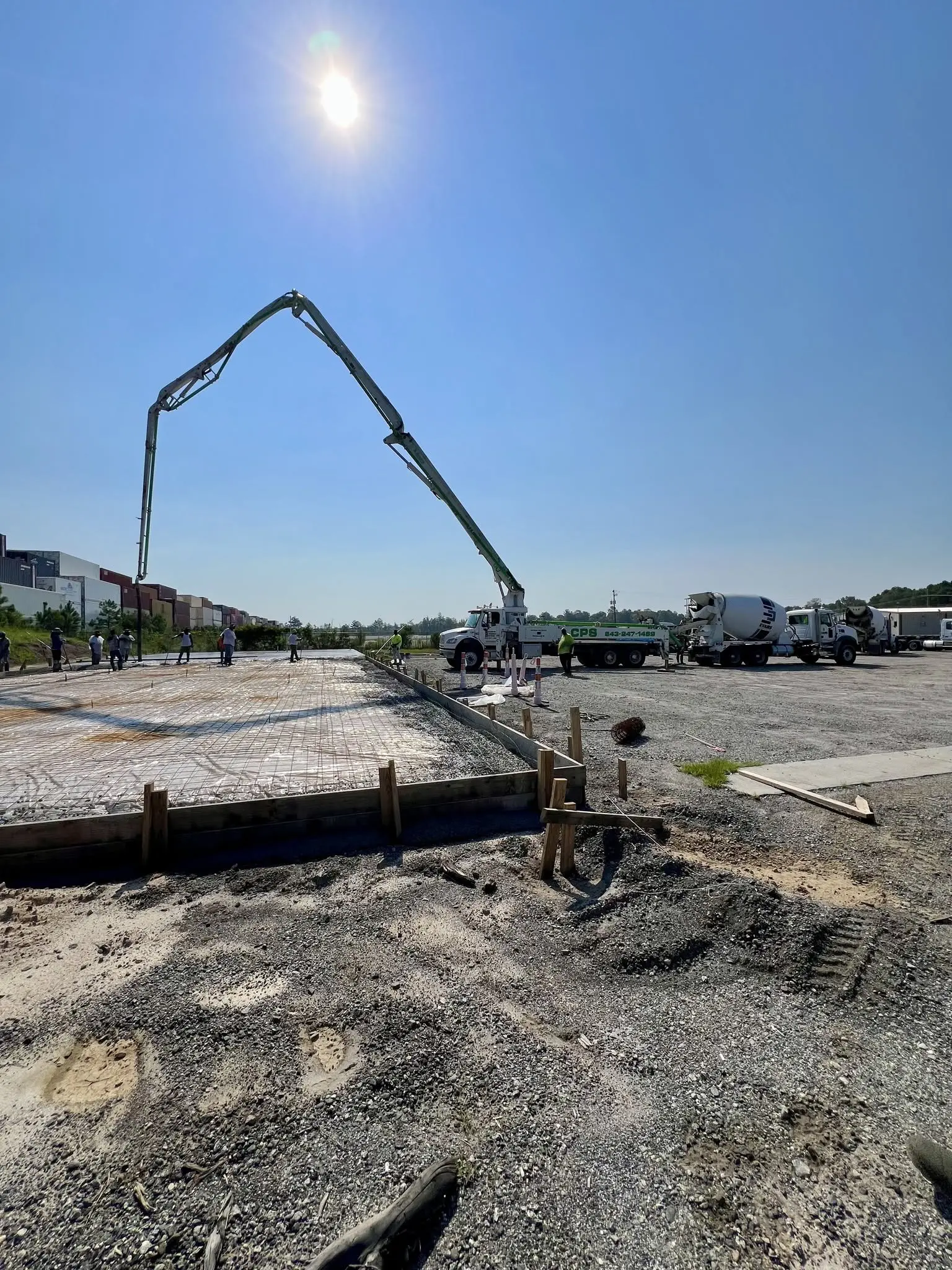 Concrete crew pouring a building foundation with a pump truck