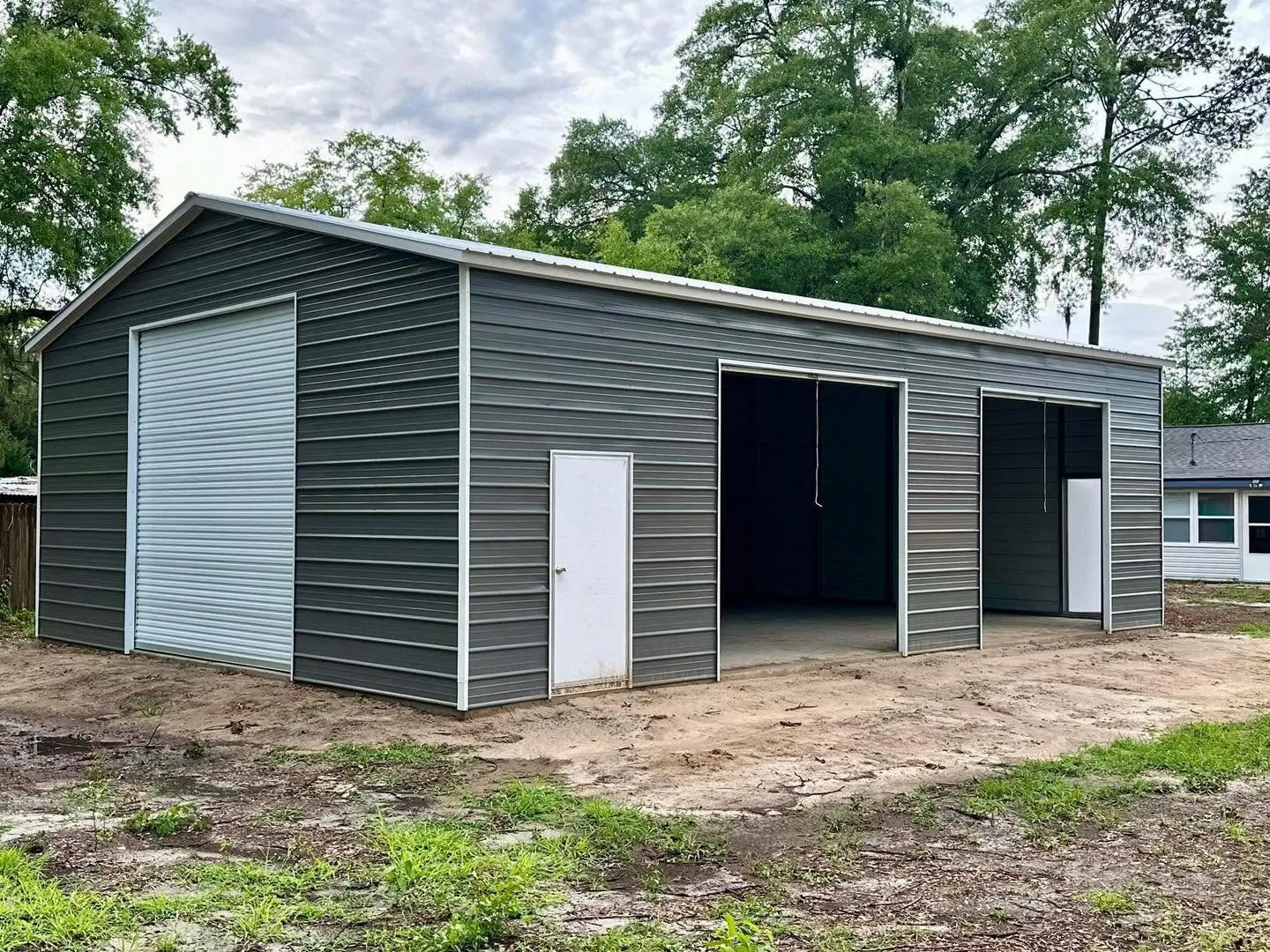 Gray steel workshop with a tall end door and two side vehicle openings
